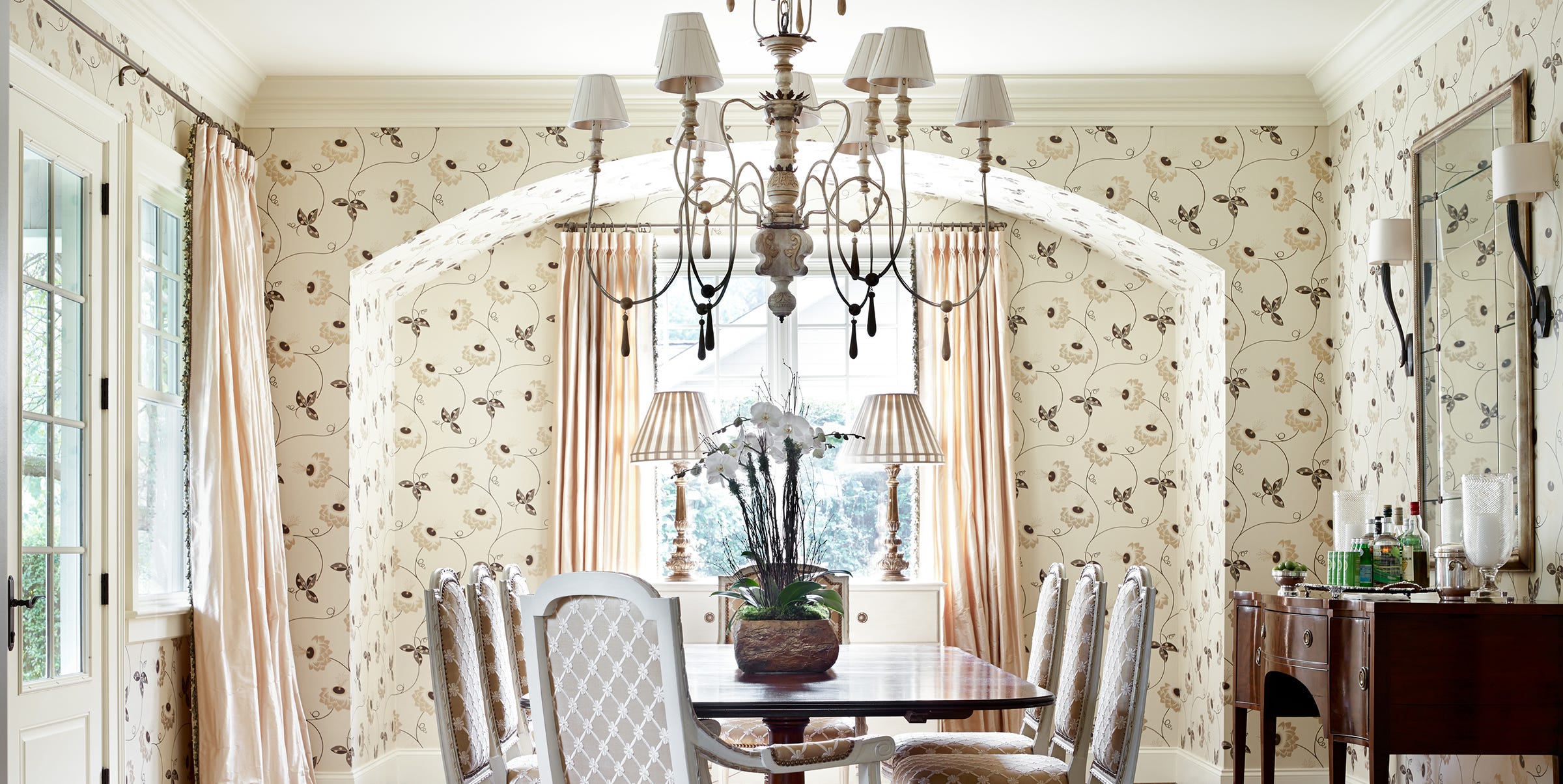Bright dining room with floral wallpaper and chandelier